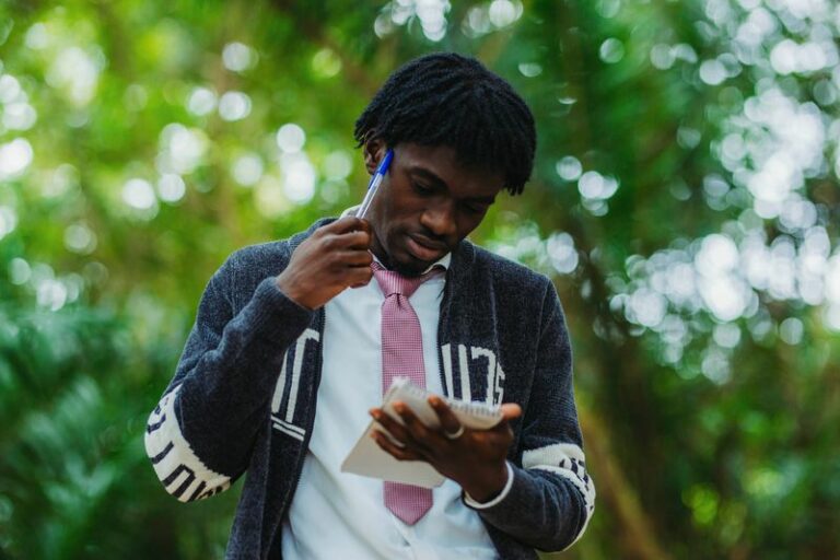 Portrait d’un jeune journaliste prenant des notes en extérieur