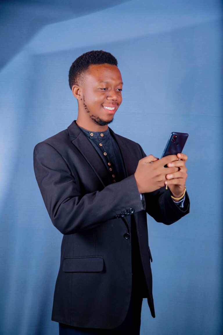 Portrait d’un community manager souriant avec un téléphone